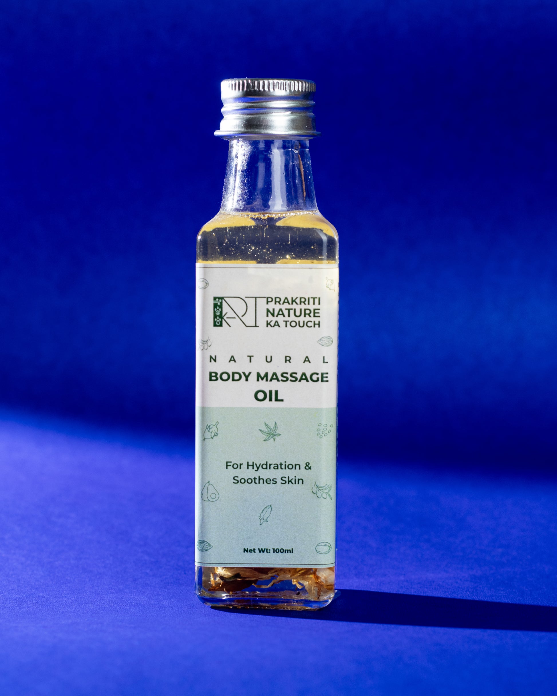 PNKT Natural Body Massage Oil - Glass bottle with ayurvedic blend on blue background - 100ml