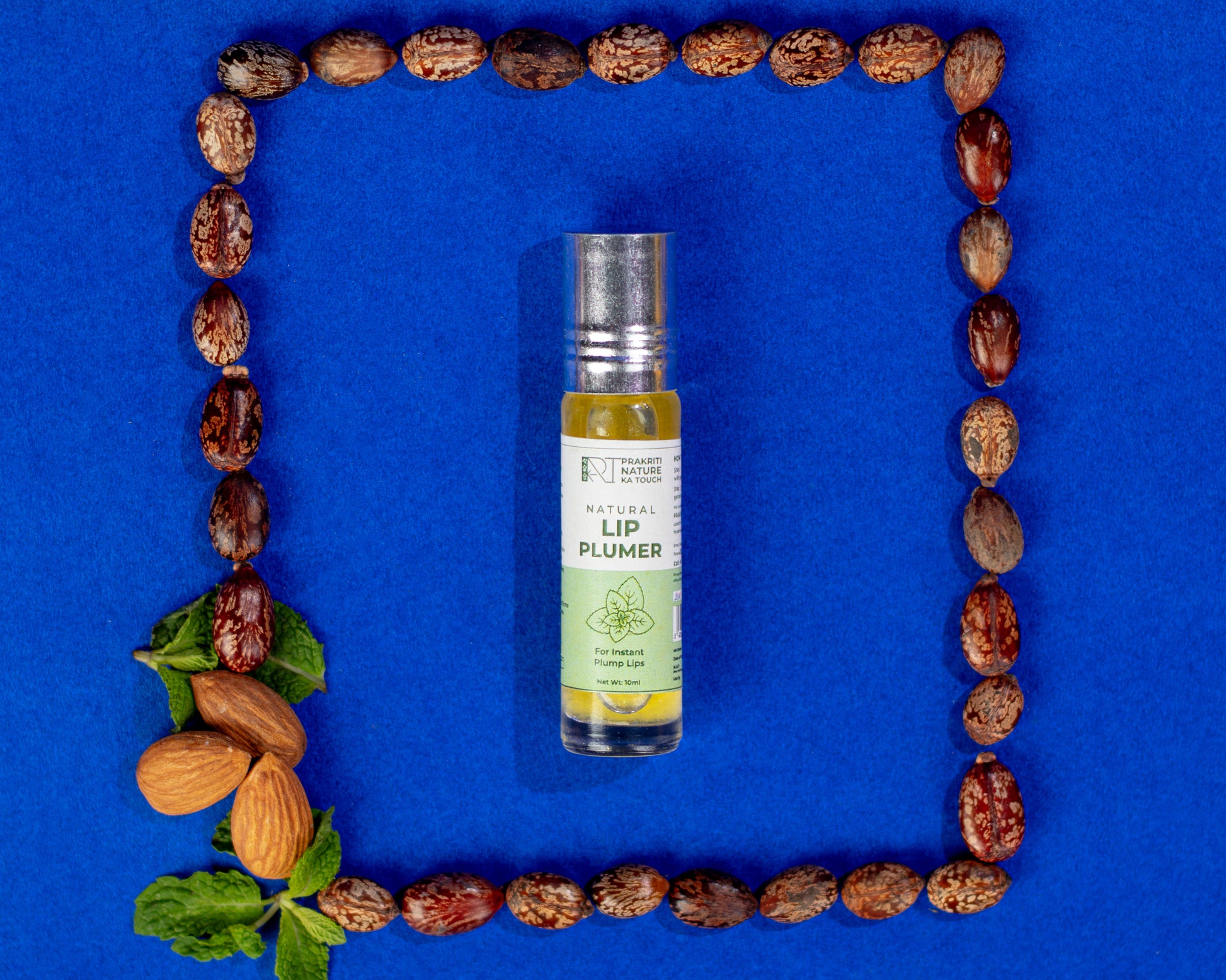 A clear bottle of PNKT Natural Lip Plummer with a white label, placed in the center of a grid of almonds and leaves on a blue background.