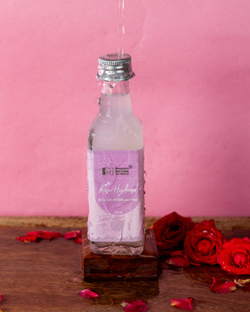 PNKT Distilled Rose Water - 100ml bottle on pink background with roses at the bottom - Pure hydrosol toner