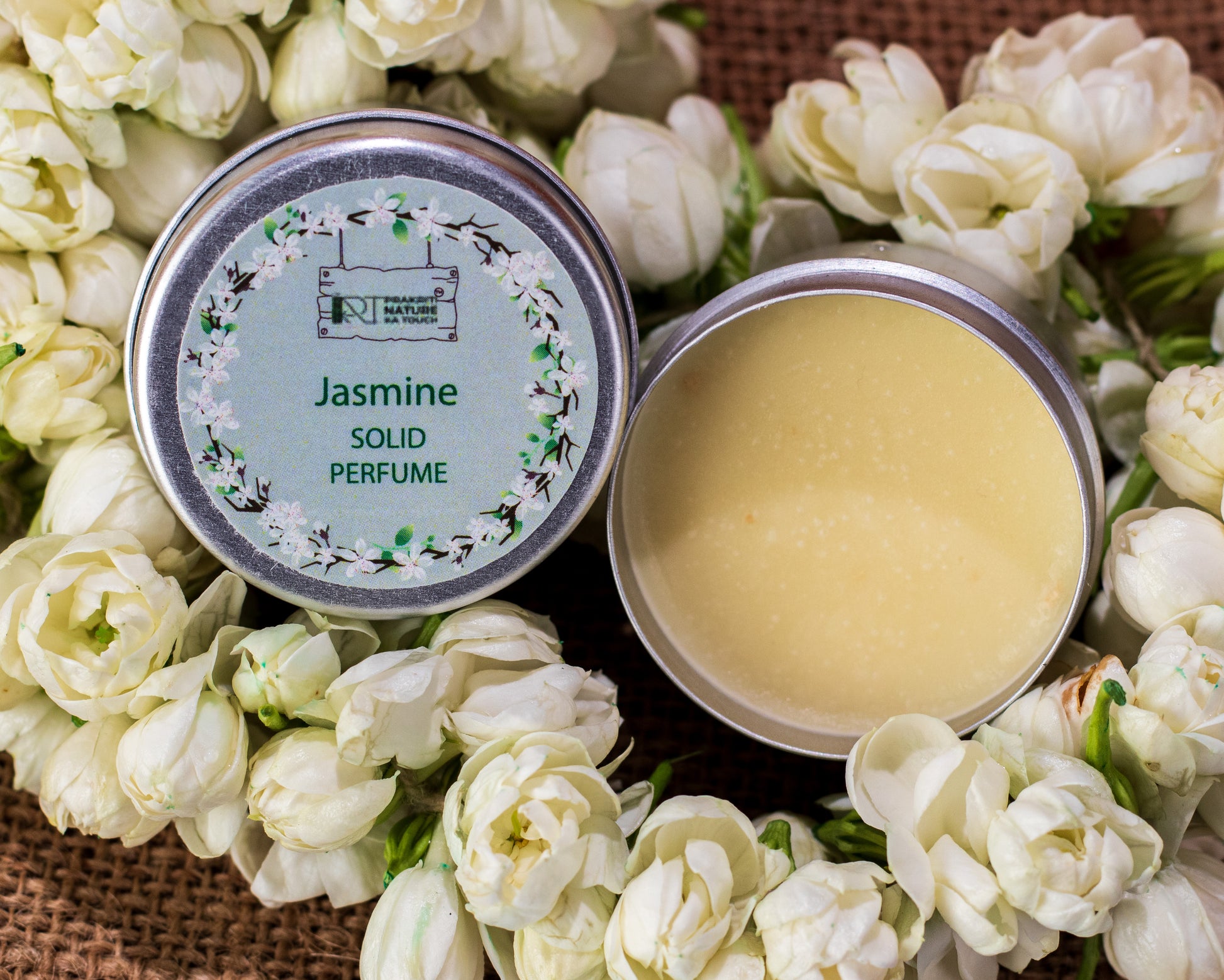 PNKT Natural Solid Perfume - Jasmine scent variant with jasmine flowers in background - Sweet exotic floral fragrance